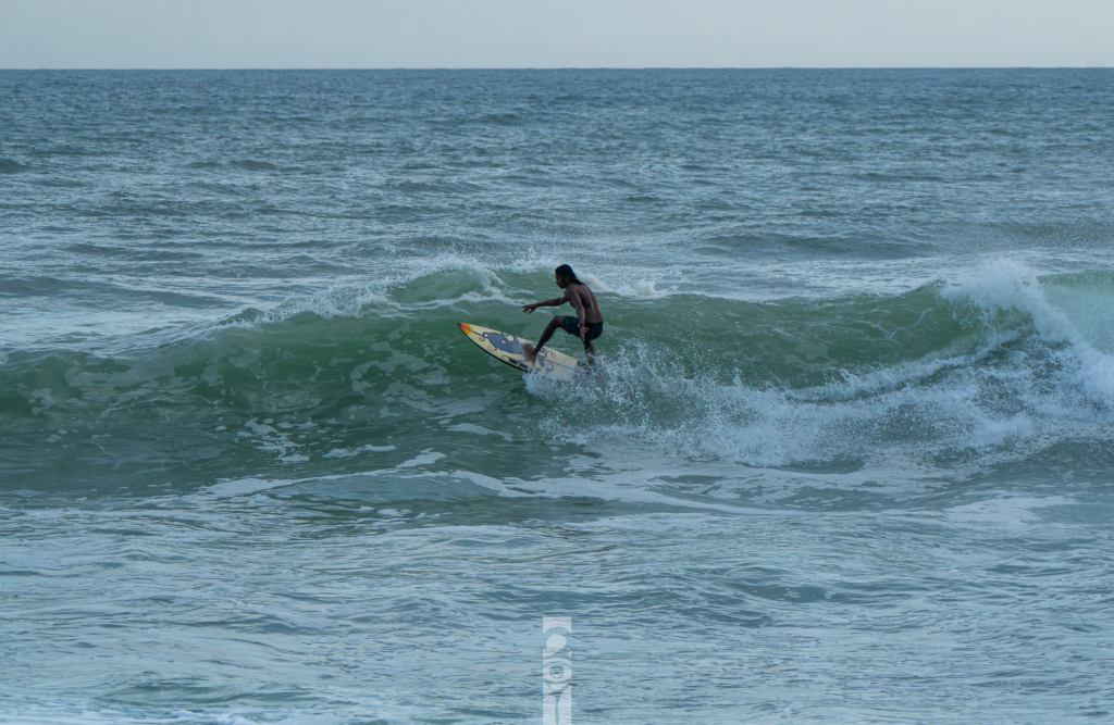 Noel Forseas, creative lifestyle photographer Carolina. A man surfing a wave at the sea.